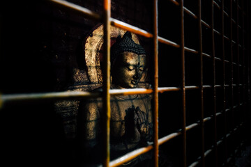 Naklejka premium Old Buddha statue in the rusty iron cage.