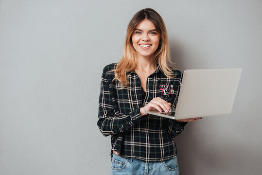 Portrait of a happy cheerful girl using laptop computer