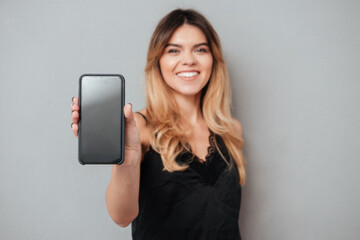 Fototapeta premium Portrait of a confident woman showing blank screen mobile phone