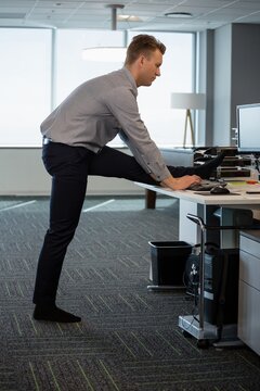 Executive Performing Stretching Exercise At Desk