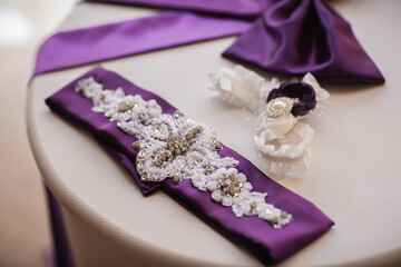 Details and elements of wedding dress on white table. Purple or violet wedding concept