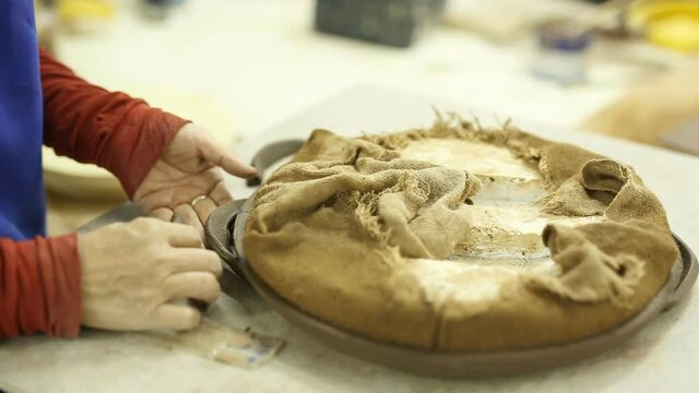 Making pottery on a wheel under production process in a factory.