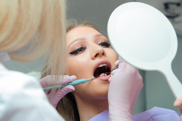 Young woman having medical checkup in the dentist office by the doctor