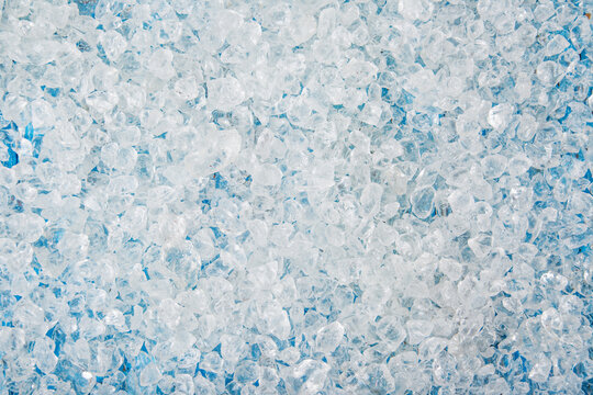 Crushed ice cubes on vintage blue wooden table.