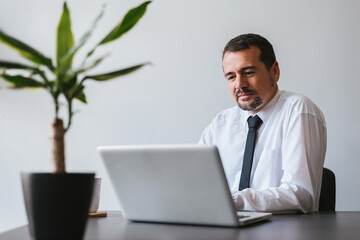 Portrait of smiling businessman in front of computer.