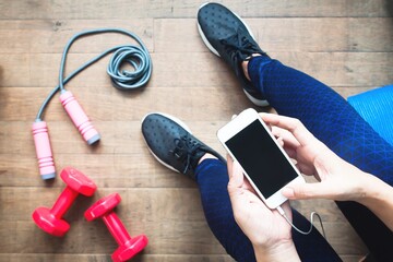 Woman in fitness clothing using smartphone. Fitness and Diet, Healthy Lifestyle concept
