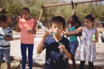 Schoolkids playing with bubble wand