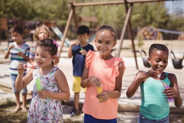 Schoolkids playing with bubble wand