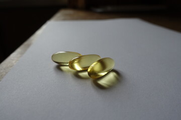 Three softgels of evening primrose oil supplement lying on the table