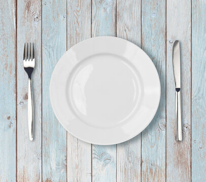 white empty dinner plate setting on blue wooden table