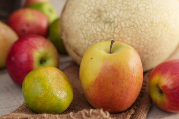 apples and oranges on sackcloth.