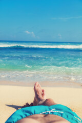 Man enjoying at the beach - focus is on feet.