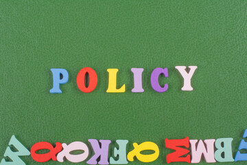 POLICY word on green background composed from colorful abc alphabet block wooden letters, copy space for ad text. Learning english concept.