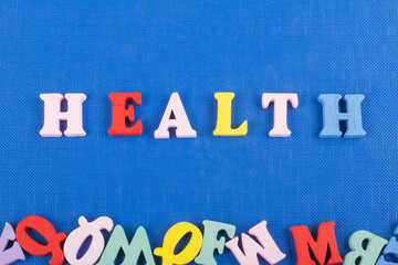 HEALTH word on blue background composed from colorful abc alphabet block wooden letters, copy space for ad text. Learning english concept.