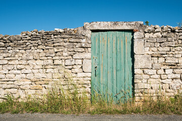 Fototapeta na wymiar mur vieux pierre porte chemin herbes île ile village campagne île de ré
