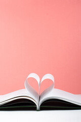 Old open hardback book, page decorate into a heart shape for love in Valentine's. love with open book heart.