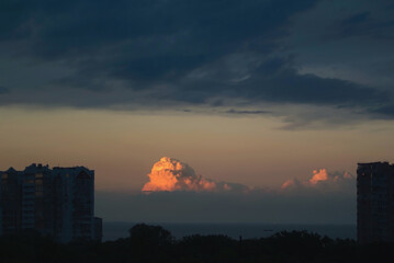 Highlighted red and orange colorful clouds during sunset in the city