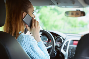 woman using smartphone while driving a car