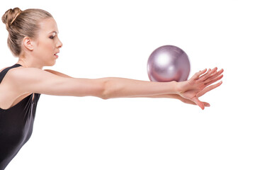 Side view of beautiful young rhythmic gymnast exercising with ball isolated on white