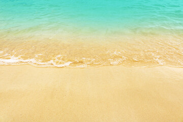 Fototapeta na wymiar Soft wave on the beach. Summer season on empty tropical beach with waves and clear sand.