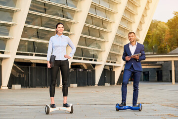 Business people on hoverboards. Man and woman smiling outdoors. Society of the future. - Powered by Adobe