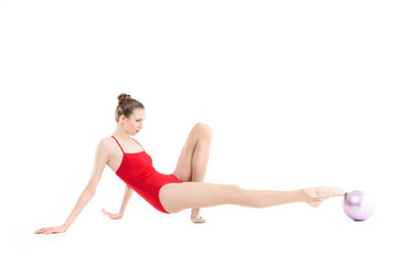 focused rhythmic gymnast exercising with ball isolated on white