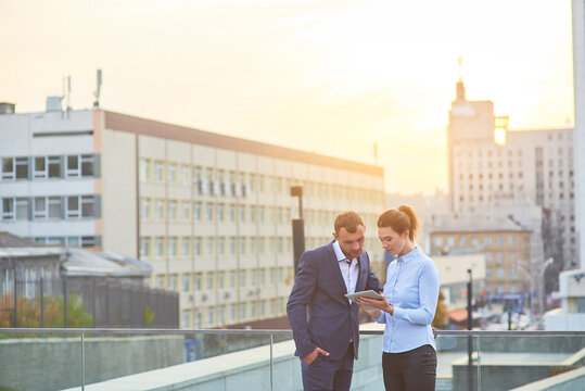 Business Couple In The City. Man And Woman With Tablet.