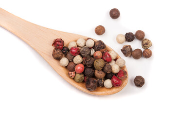 Mixture of peppers hot, red, black, white and green pepper in a wooden spoon isolated on white background. Top view