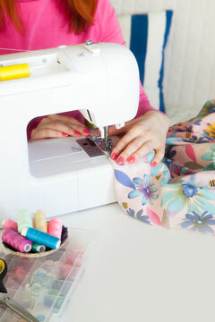 Young woman sewing while sitting at her working place
