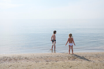 two kids playing on beach in summer time