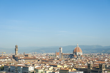 Scenic skyline view of Florence, Italy dominated by the terra-cotta dome of the Cattedrale di Santa Maria del Fiore, also known as Il Duomo di Firenze, and the Tower of Arnolfo, in Palazzo Vecchio