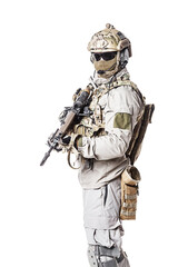 Fototapeta premium Army soldier in Protective Combat Uniform holding Special Operations Forces Combat Assault Rifle. Knee pads, mag recovery pouch, chest rig, military boots. Studio shot, isolated on white background