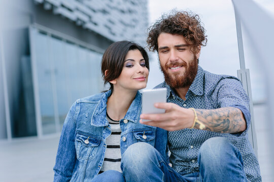 Young couple sitting taking a selfie