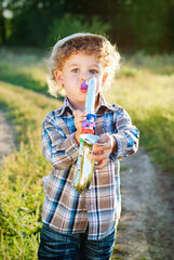 Cute boy with curly hair outdoor - beauty and fashion concept