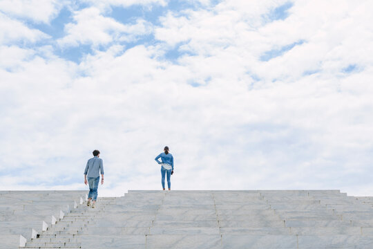 Two young people standing high on some steps