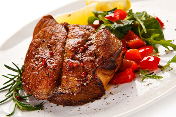 Grilled beefsteak with vegetables on white background