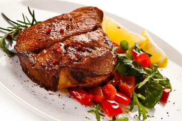 Grilled beefsteak with vegetables on white background