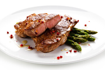 Grilled beefsteak with asparagus on white background