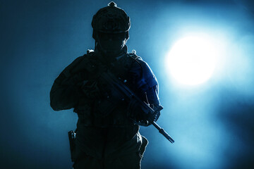 Army soldier in Protective Combat Uniform holding Special Operations Forces Combat Assault Rifle....