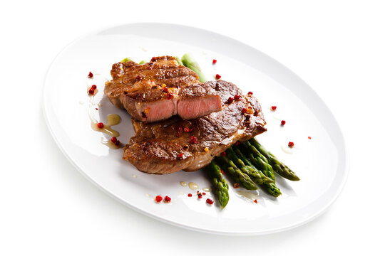 Grilled beefsteak with asparagus on white background