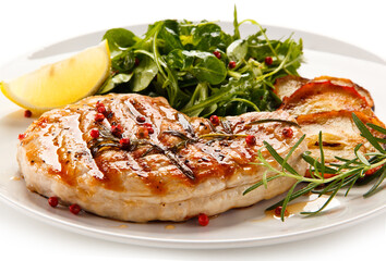 Grilled steak with vegetables and roast apples on white background