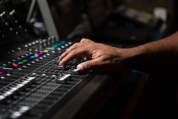 Hand of male audio engineer using sound mixer - obrazy, fototapety, plakaty