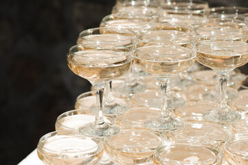 A lot of wine glasses with a cool delicious champagne or white wine at the bar. Alcohol background.