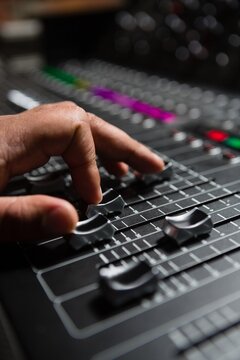 Hand of male audio engineer using sound mixer
