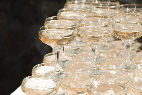 A lot of wine glasses with a cool delicious champagne or white wine at the bar. Alcohol background.