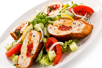 Salad with stuffed chicken fillet on white background