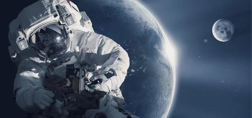 Foto op Canvas Astronaut in de ruimte tegen de achtergrond van de planeet aarde. Elementen van deze afbeelding geleverd door NASA. © santoelia