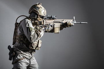 Army soldier in Protective Combat Uniform holding Special Operations Forces Combat Assault Rifle....