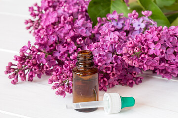 Obraz na płótnie Canvas Bottle with aroma oil and lilac flowers