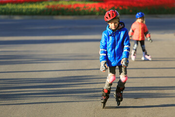 little boy and girl learn to roller skate